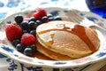 breakfast spread with pancakes, syrup, and berries