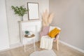 Breakfast still life scene. Coffee cup teapot white table, empty picture frame mockup, cozy stylish armchair blanket. Elegant