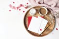 Breakfast still life scene. Cup of coffee, Gypsophila flowers, paper hearts confetti, candle and blank greeting card