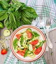 Salad of tomatoes and cucumbers with green onions and basil.