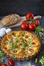 Omelet in the oven with green beans, tomatoes, herbs and cheese. Food on dark background.