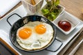 Breakfast - Sunny side up fried eggs with tomato sauce and potato wedges