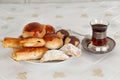 A breakfast table with bagels, pastries, cakes and tea.