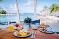 breakfast on a table by the beach looking out over the ocean, Caribbean sea with breakfast table with coffee orange