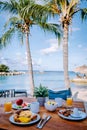 breakfast on a table by the beach looking out over the ocean, Caribbean sea with breakfast table with coffee orange