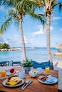 breakfast on a table by the beach looking out over the ocean, Caribbean sea with breakfast table with coffee orange