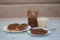 chocolate paste on bread and a jar,breakfast on the table bread with chocolate butter and milk Royalty Free Stock Photo