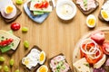 Breakfast table with cheese sandwiches, sausage, vegetables, hard boiled eggs and fruits Royalty Free Stock Photo