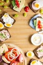 Breakfast table with cheese sandwiches, sausage, vegetables, hard boiled eggs and fruits Royalty Free Stock Photo