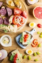 Breakfast table with cheese sandwiches, sausage, vegetables, hard boiled eggs and fruits Royalty Free Stock Photo