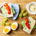 Breakfast table with cheese sandwiches, sausage, vegetables, hard boiled eggs and fruits Royalty Free Stock Photo