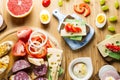 Breakfast table with cheese sandwiches, sausage, vegetables, hard boiled eggs and fruits Royalty Free Stock Photo