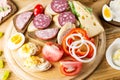 Breakfast table with cheese sandwiches, sausage, vegetables, hard boiled eggs and fruits Royalty Free Stock Photo