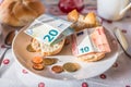 breakfast table with coffee sugar milk and butter and roll covered with euro coins and banknotes on plate, Germany Royalty Free Stock Photo