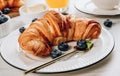 Breakfast table with croissants, coffee, orange juice and blueberries Royalty Free Stock Photo