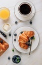 Breakfast table with croissants, coffee, orange juice and blueberries Royalty Free Stock Photo