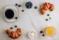 Breakfast table with croissants, coffee, orange juice and blueberries Royalty Free Stock Photo