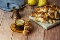 Rustic home made croissants on a wooden table with coffee in a cup and a copper cezve behind