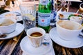 Breakfast Table With Eaten Food And Bottles Of Water With Empty Coffee Cups