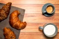 Breakfast table with espresso, milk and croissants of various flavors.