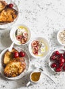 Breakfast table. Greek yogurt with cherries and honey and caramel french toast on white table, top view. Flat lay.