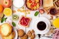 Breakfast table with healthy tasty ingredients. Coffee, toast, jam, cheesecakes, corn flakes, cookies, almonds, milk, orange juice Royalty Free Stock Photo