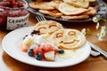 Breakfast table: pancakes, fruit salad, jam, yogurt