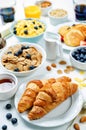 Breakfast table setting with flakes, juice, croissants, pancakes Royalty Free Stock Photo