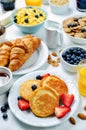 Breakfast table setting with flakes, juice, croissants, pancakes Royalty Free Stock Photo