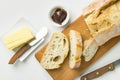 Breakfast table setting. Freshly baked artisan sliced bread on wood cutting board stick of organic butter homemade marmalade Royalty Free Stock Photo