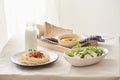 Breakfast table; spaghetti served with radish and salad with pumpkin puree, bread, milk set on table