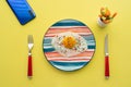 breakfast table sunny side up on colorful plate, sliced carrot cucumber on yellow background smart phone. red fork, knife. spice Royalty Free Stock Photo