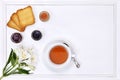 Breakfast table with tea, cup of tea, flower, jam and bread Royalty Free Stock Photo
