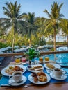 breakfast table with view over ocean and swimming pool, tropical view on vacation Royalty Free Stock Photo