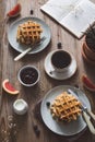 Breakfast table with waffles, coffee, jam, fruits and book for reading Royalty Free Stock Photo