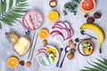 Breakfast table with yogurt strawberry smoothie bowls and fresh tropic fruits on a gray stone background. Acai bowl of Royalty Free Stock Photo