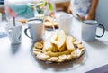 Breakfast with tea and coffee, pieces of fruit, toast with butter and nuts on the table in the kitchen in the morning Royalty Free Stock Photo