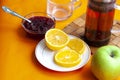 Breakfast tea in French press  lemon  cup  jam  apple  orange background Royalty Free Stock Photo