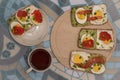 Breakfast with tea and sandwiches with avocado, cream cheese, sliced eggs, red caviar and salted salmon decorated with onion