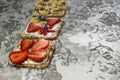 Breakfast with toaster and oat bread, buttered with butter, jam, strawberries and bananas on a concrete table. Royalty Free Stock Photo