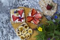 Breakfast with toaster and oat bread, buttered with butter, jam, strawberries and bananas on a concrete table. Royalty Free Stock Photo