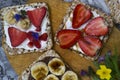 Breakfast with toaster and oat bread, buttered with butter, jam, strawberries and bananas on a concrete table. Royalty Free Stock Photo