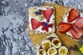 Breakfast with toaster and oat bread, buttered with butter, jam, strawberries and bananas on a concrete table Royalty Free Stock Photo