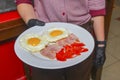 Breakfast - toasts, eggs, bacon served in a cafe or restaurant. Waiter serving breakfast to a customer Royalty Free Stock Photo