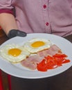 Breakfast - toasts, eggs, bacon served in a cafe or restaurant. Waiter serving breakfast to a customer Royalty Free Stock Photo