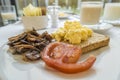 Breakfast with tomato, mushroom, scramble eggs on toast. Royalty Free Stock Photo