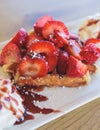 Breakfast with traditional dessert - Belgian waffle with fresh berries, whipped cream and caramel sauce syrup, plate with viennese