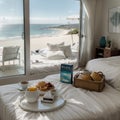 Breakfast tray and magazine on bed overlooking ocean