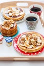 Breakfast tray with pancakes with bananas, maple syrup and nuts, cup of coffee and honey