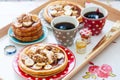 Breakfast tray with pancakes with bananas, maple syrup and nuts, cup of coffee and honey